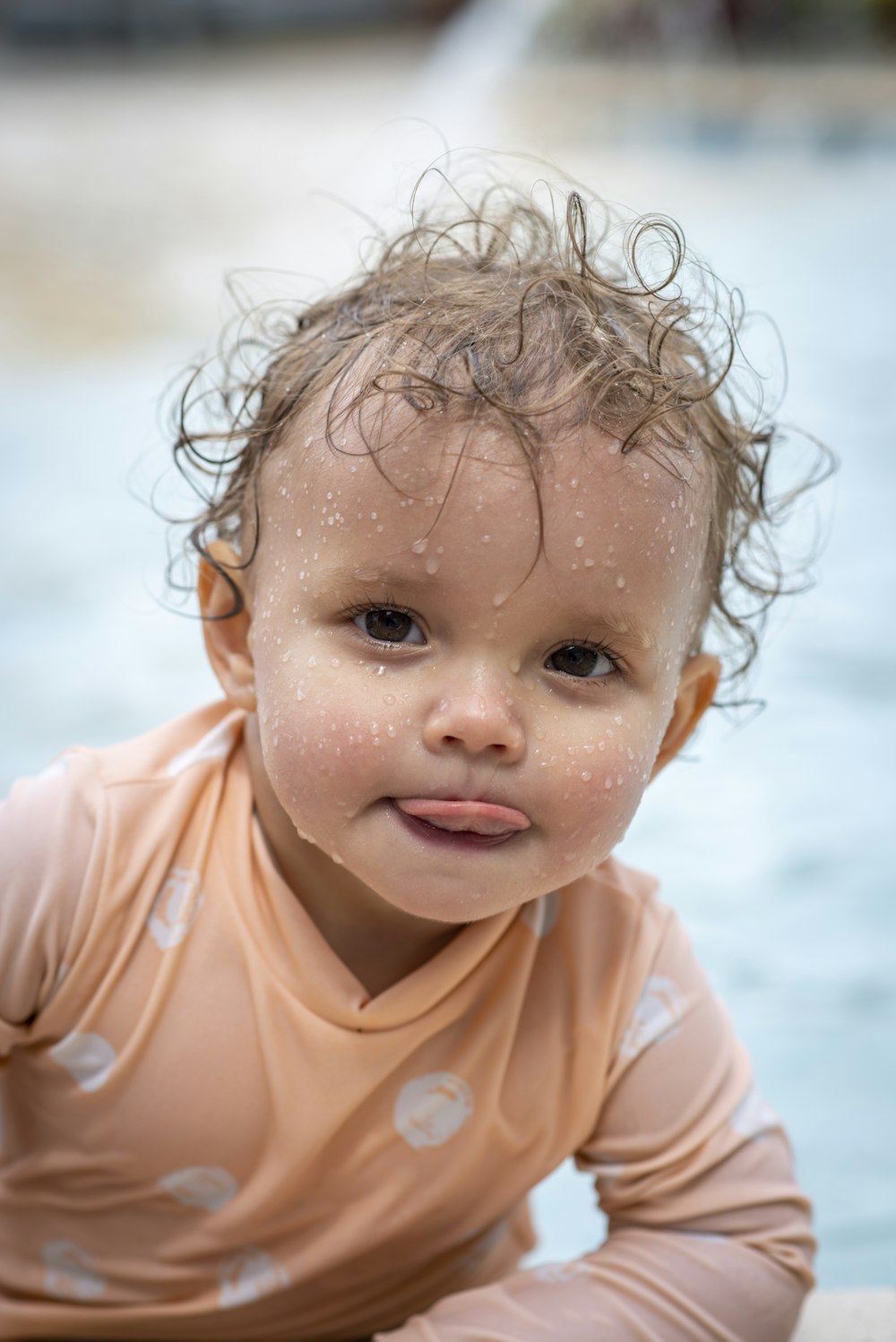 foto de foco raso da criança na camisa laranja de manga comprida de gola comprida
