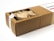 A rectangular cardboard box partially opened to reveal its contents, which include multiple paper-wrapped items. The box features a white label on top with text and a small design element.