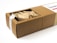 A rectangular cardboard box partially opened to reveal its contents, which include multiple paper-wrapped items. The box features a white label on top with text and a small design element.