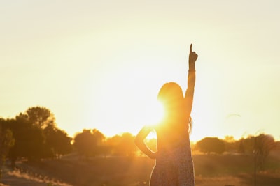 woman pointing on ttop near tree sun google meet background