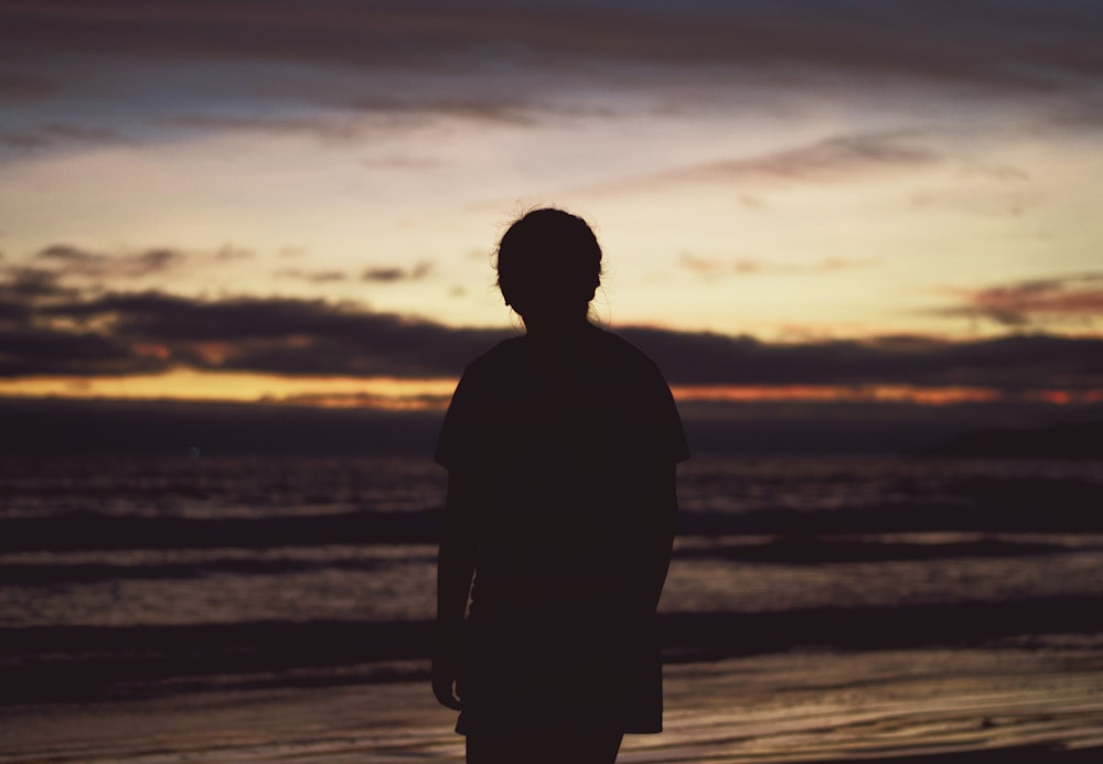 silhouette of person near ocean