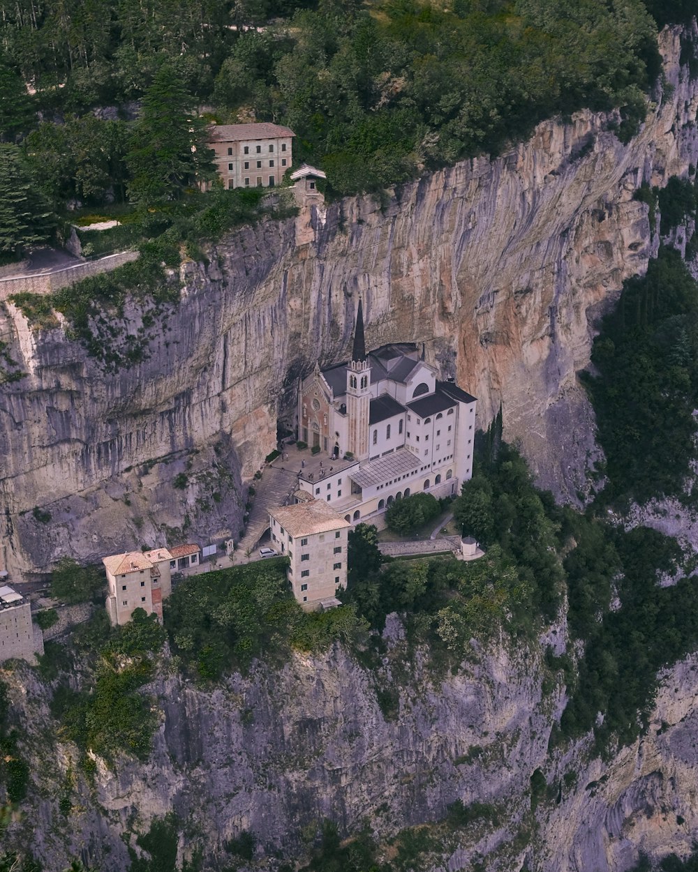 aerial photography of a cathedral on a mountain cliff