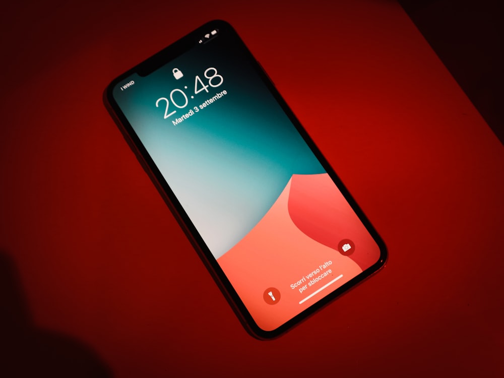 gros plan d’un téléphone cellulaire sur une surface rouge