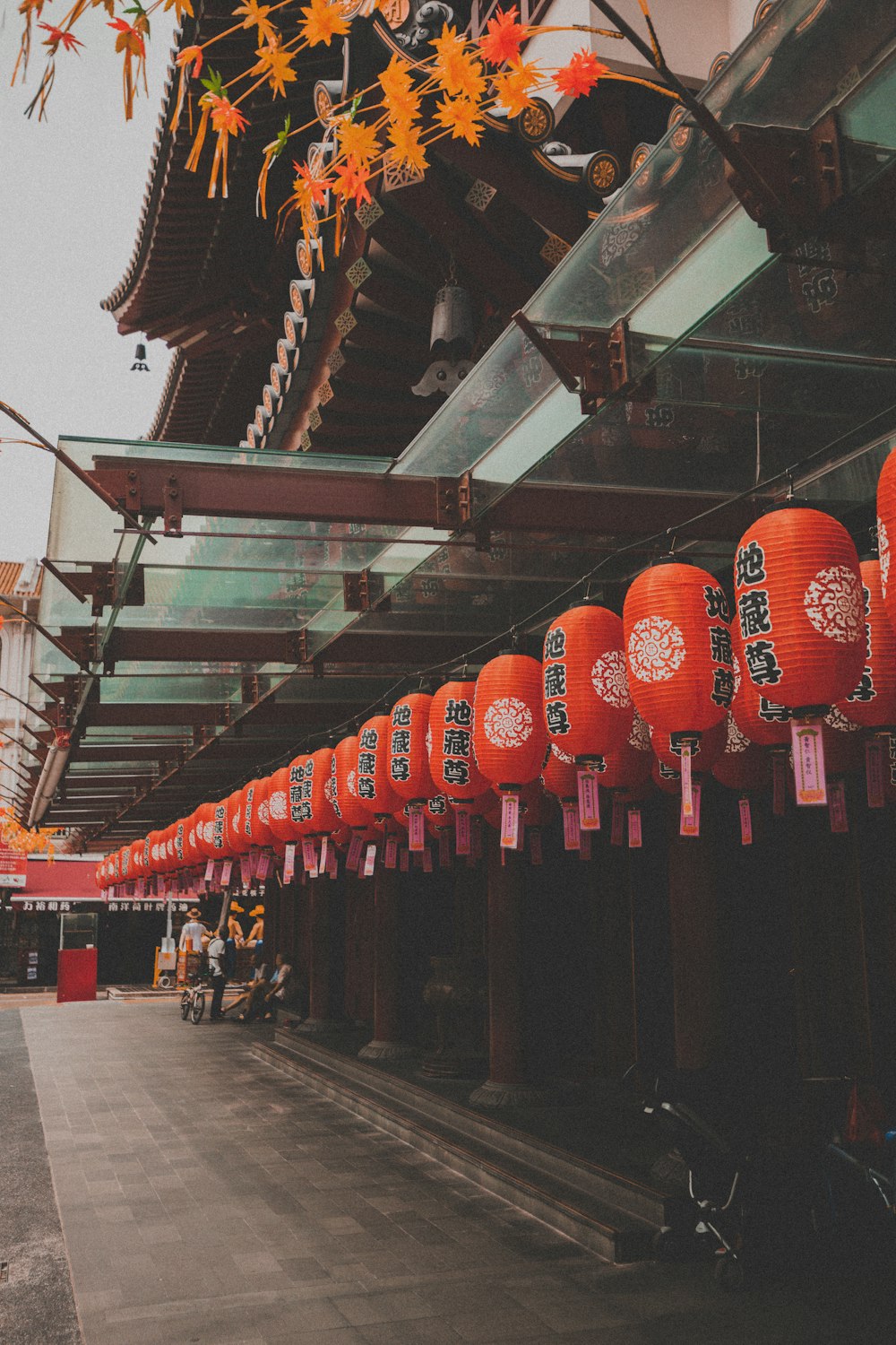 a row of red lanterns hanging from the ceiling of a building