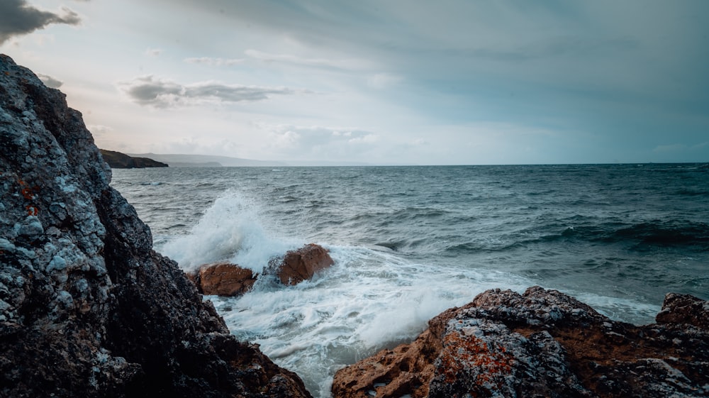 a large body of water sitting next to a rocky shore