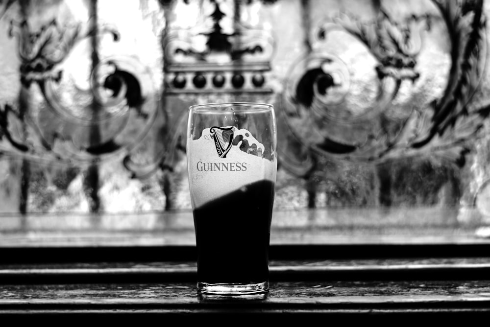 a glass of beer sitting on top of a table