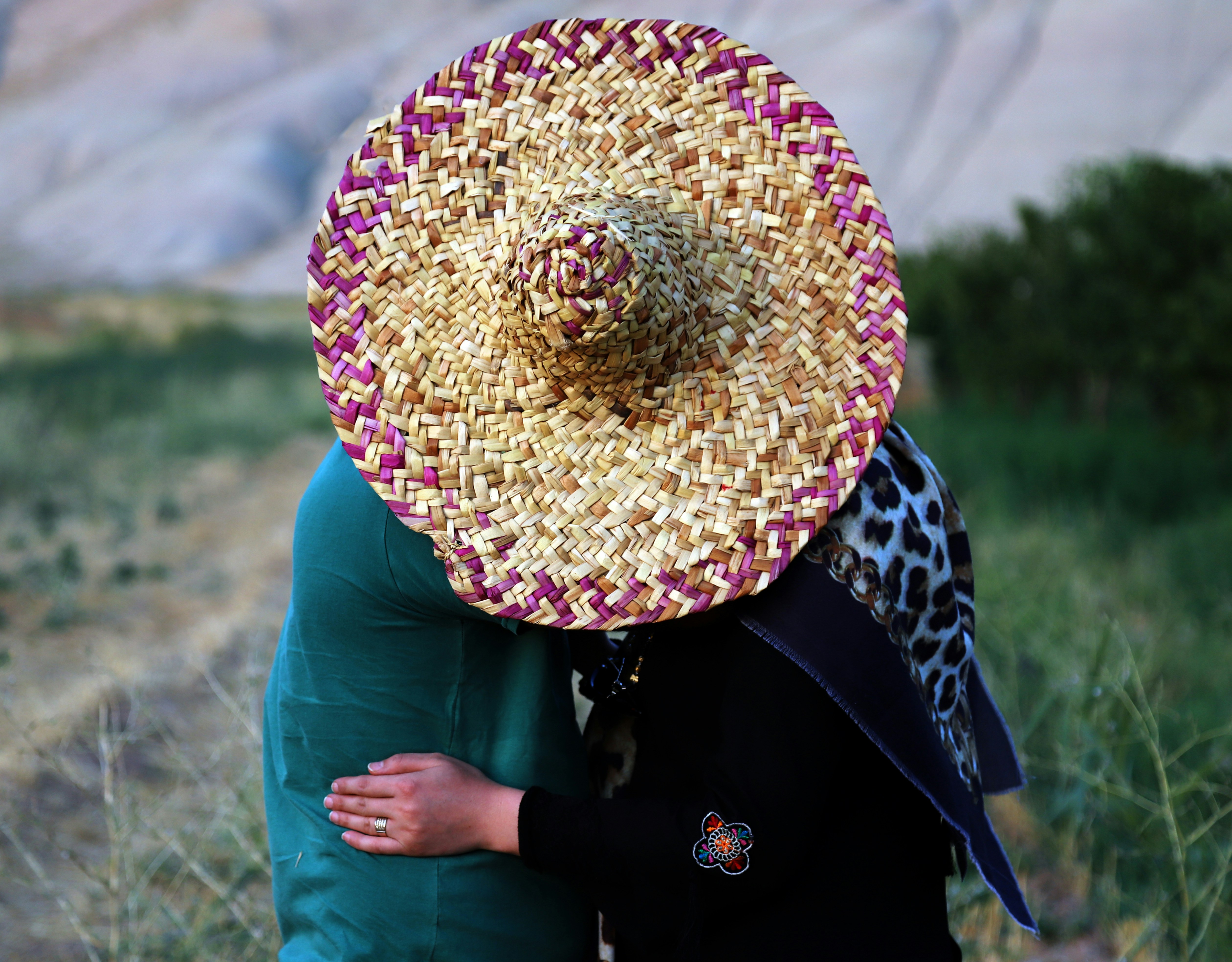 personne portant un chapeau de paille brun et rouge