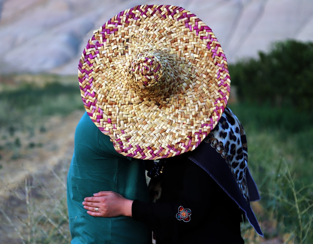 person wearing brown and red straw hat