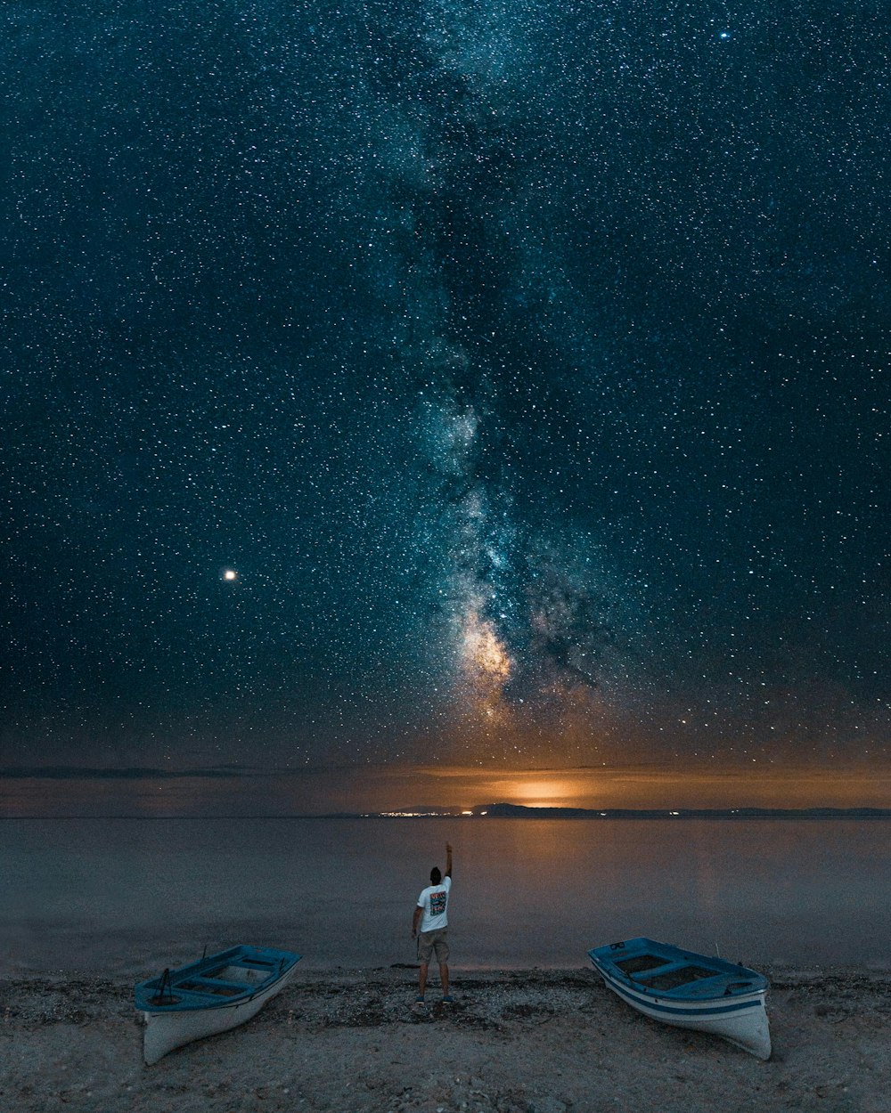 man standing between boats near sea