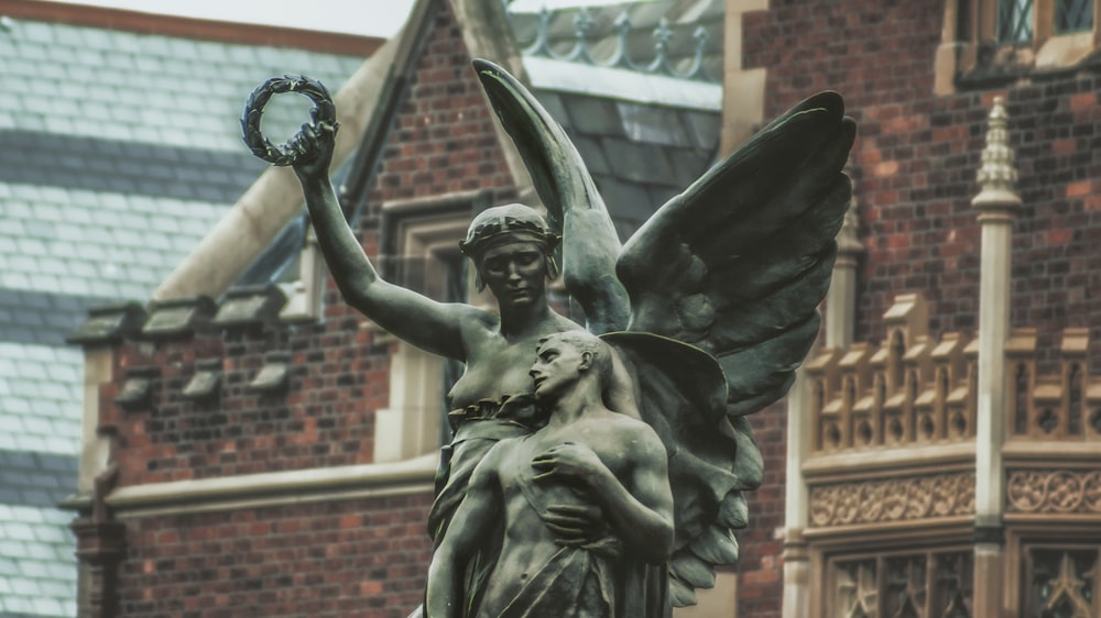 angel and human statue near building