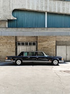 A sleek black limousine parked in front of a Houston skyline at dusk