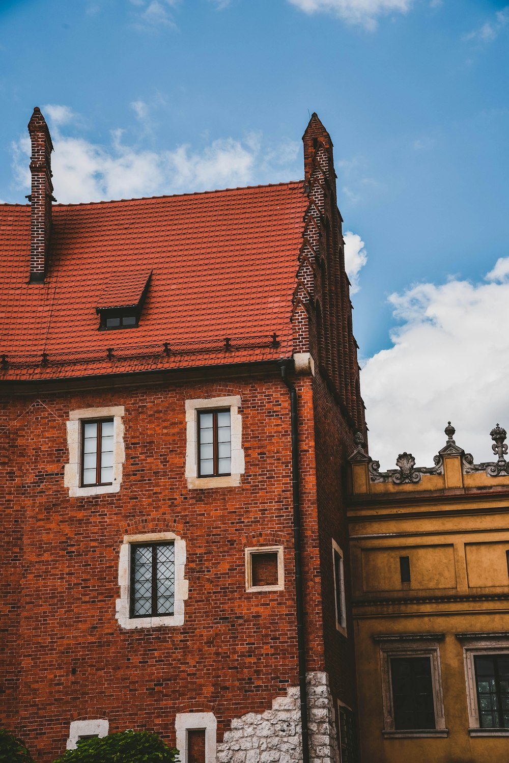 a tall brick building with a red roof