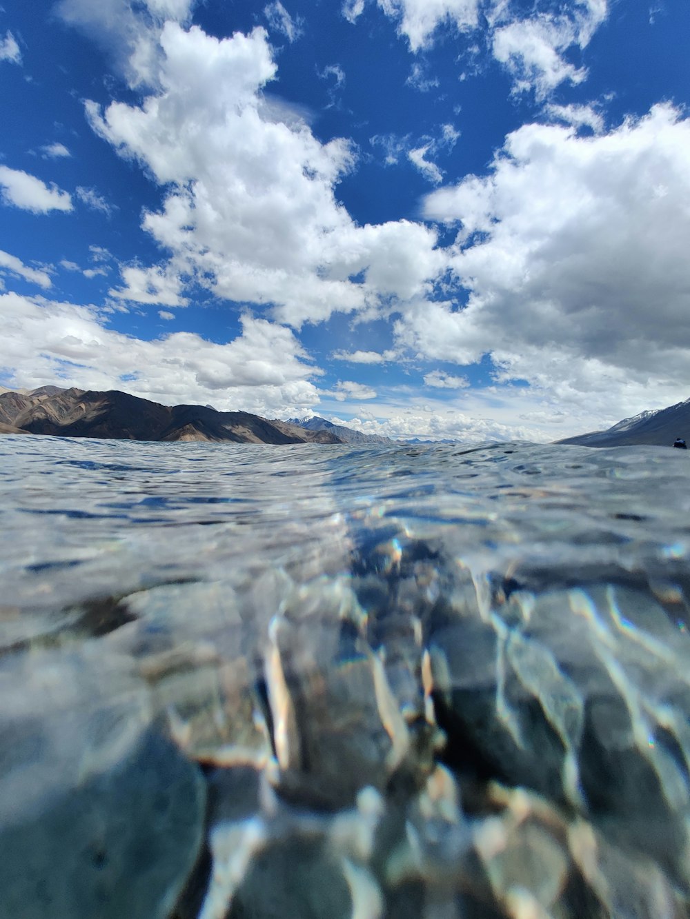 clear water under white clouds during daytime