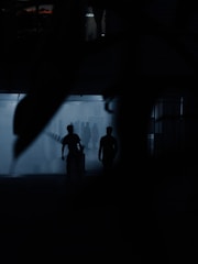 Players cautiously navigating a dimly lit room with eerie shadows lurking.