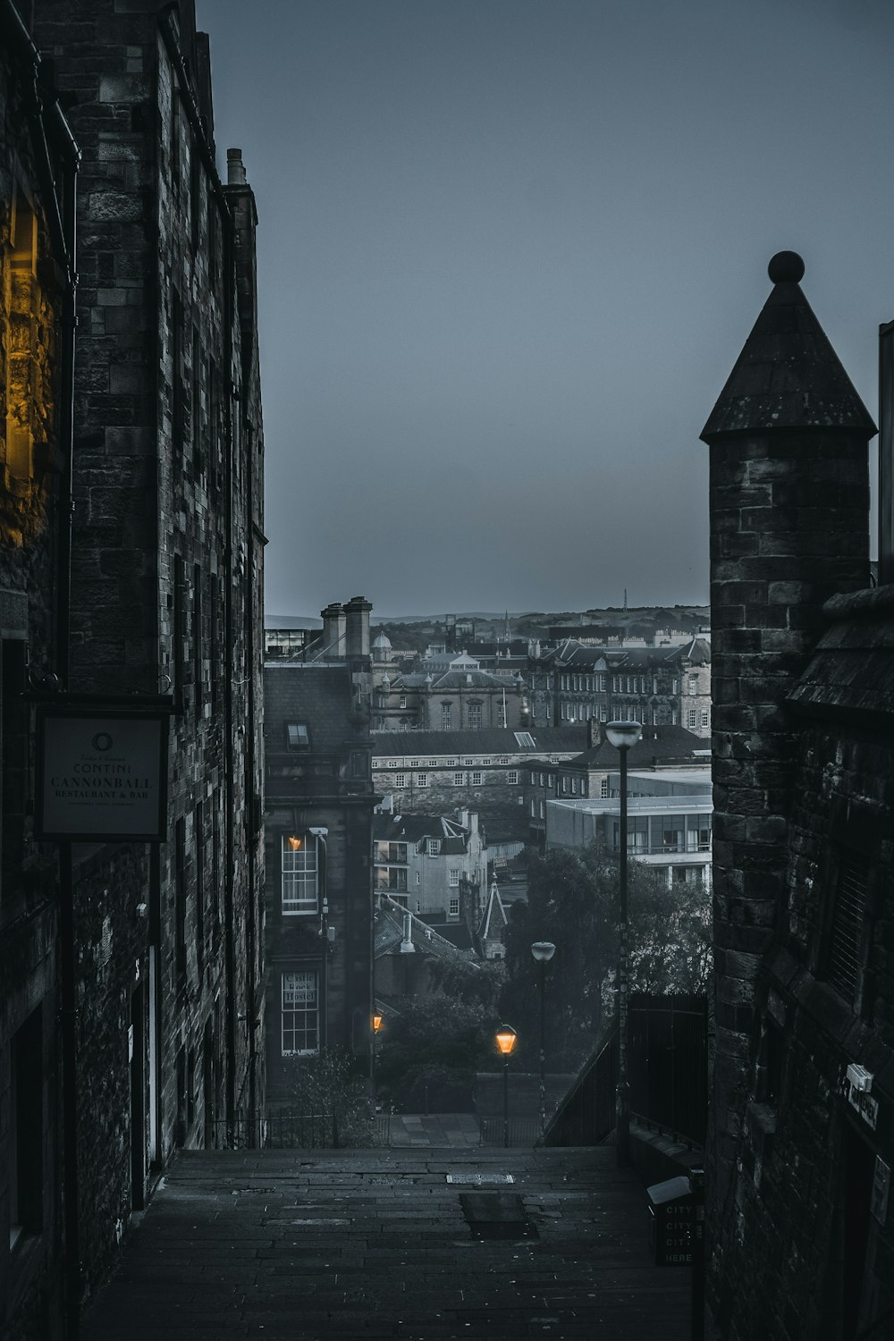 a dark alley way with buildings in the background