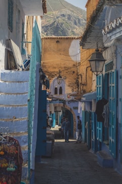 man walking beside blue house