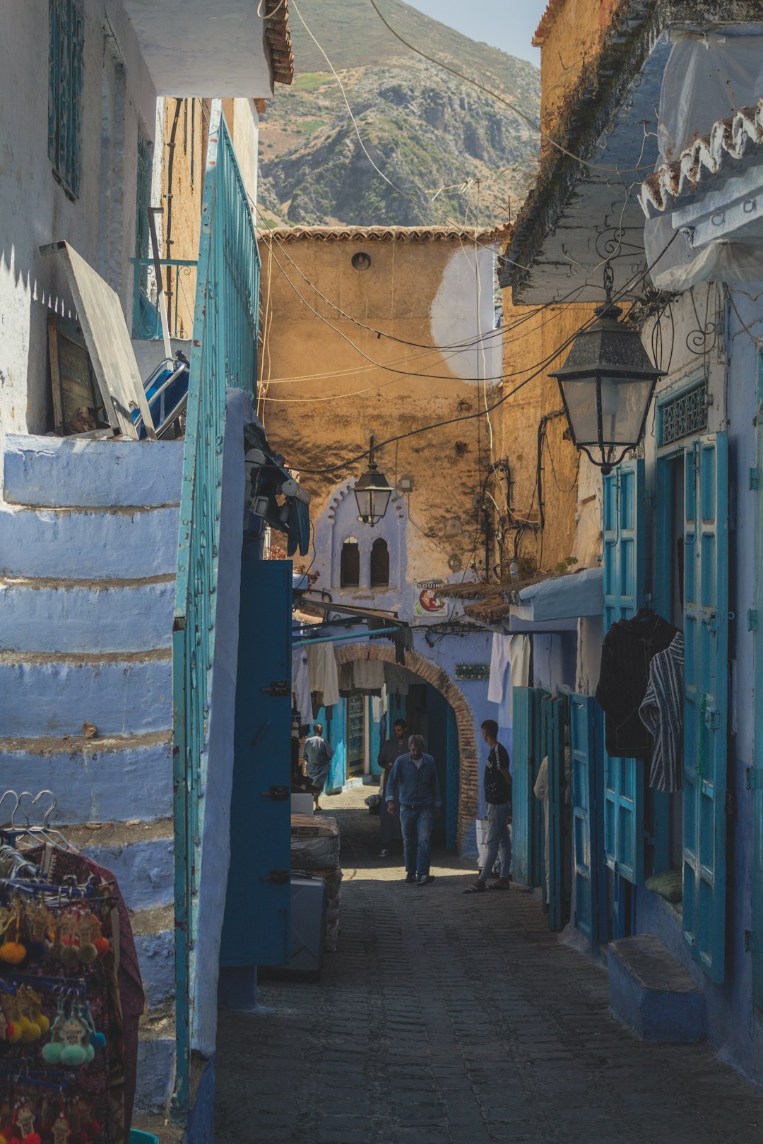 man walking beside blue house