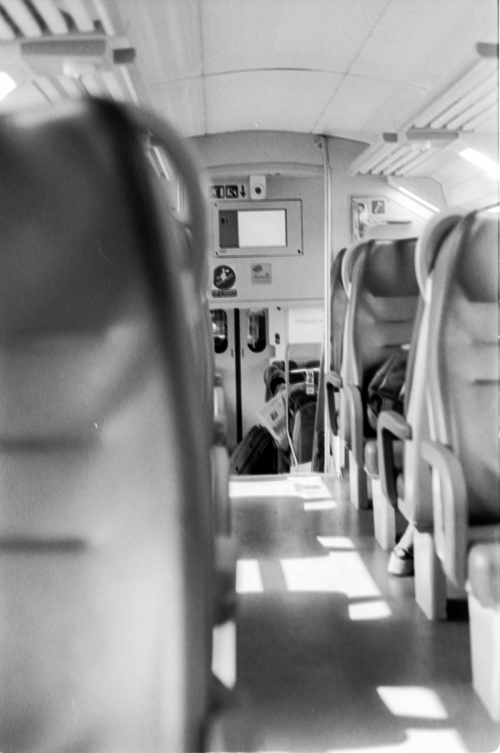 Graustufenfotografie des Flugzeugpassagiersitzes