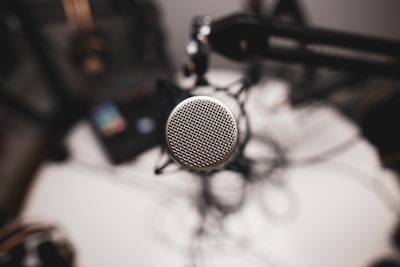 A sleek black-and-white close-up of a microphone with subtle Joe Rogan podcast branding in the background.