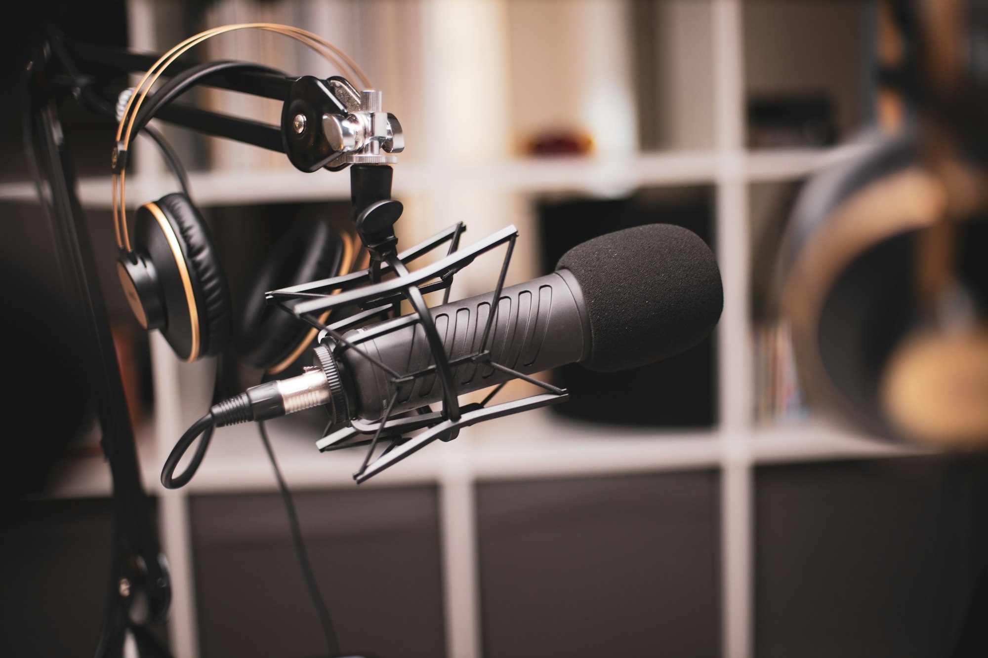 Side on a shot of a podcasting set-up with headphones and a professional microphone