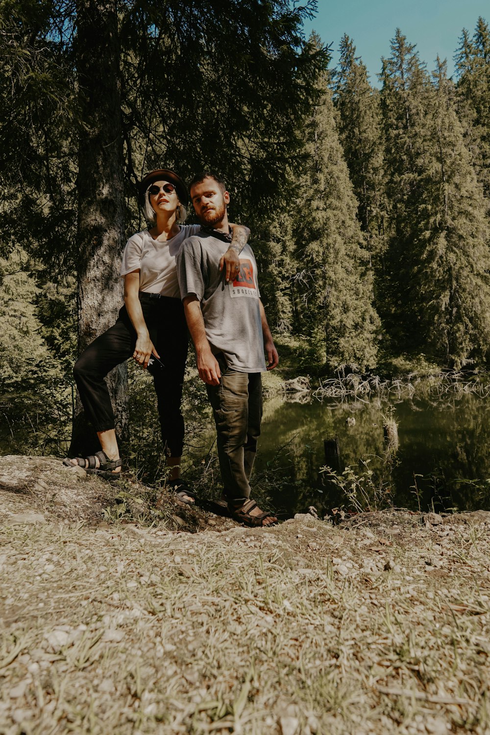 man and woman standing beside calm water at daytime