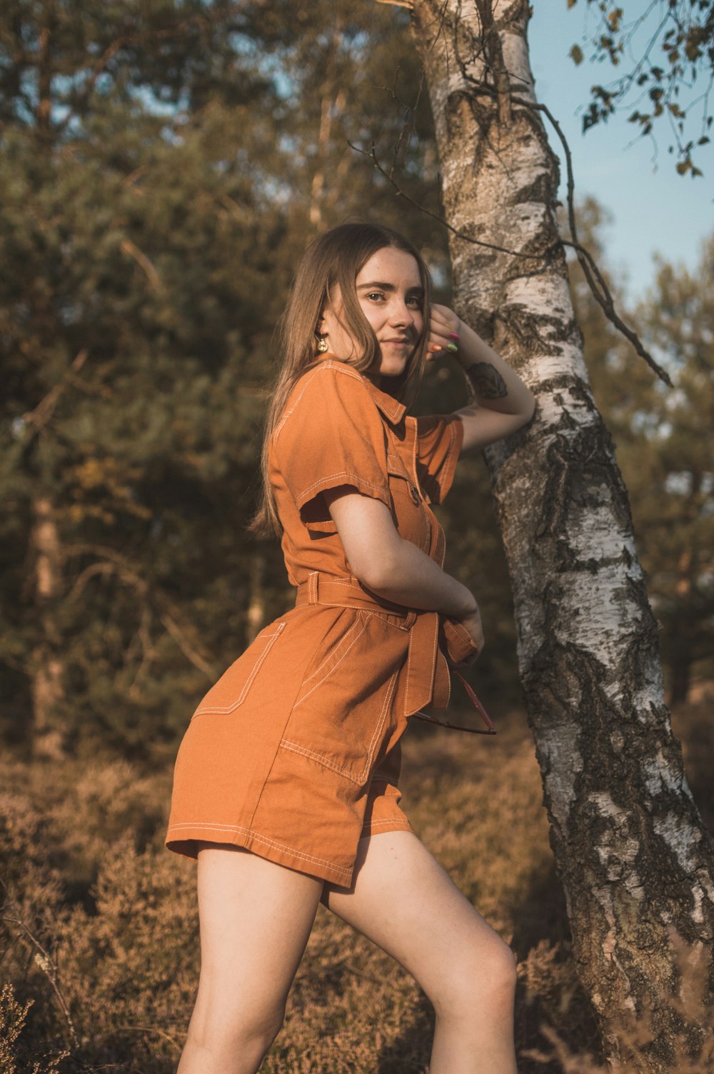 woman leans on tree