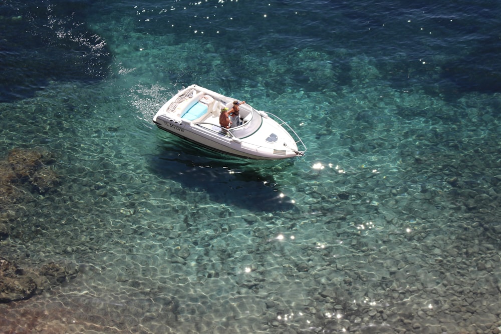 Dos personas montadas en un barco blanco