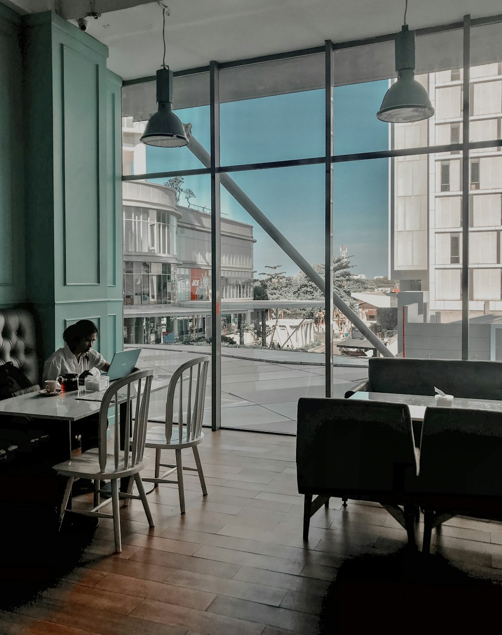 person sitting near table using laptop inside building