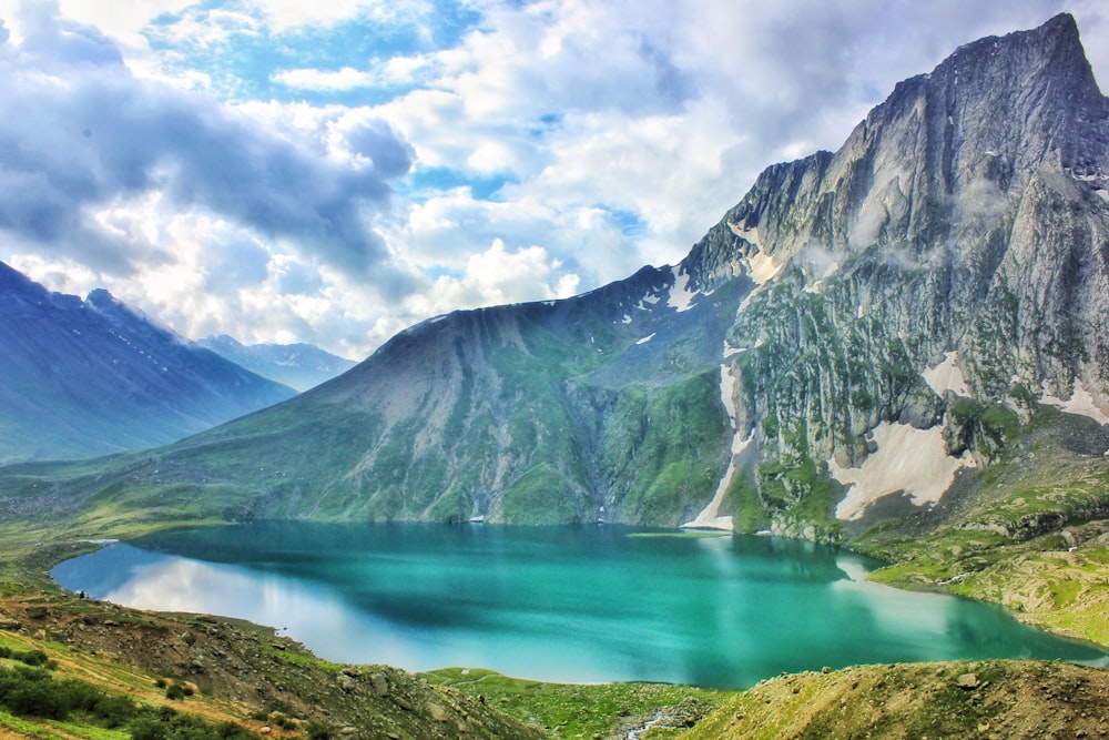 lake and mountain under cloudy sky