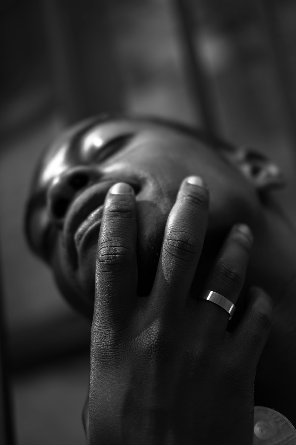 a black and white photo of a person with their hand on their face