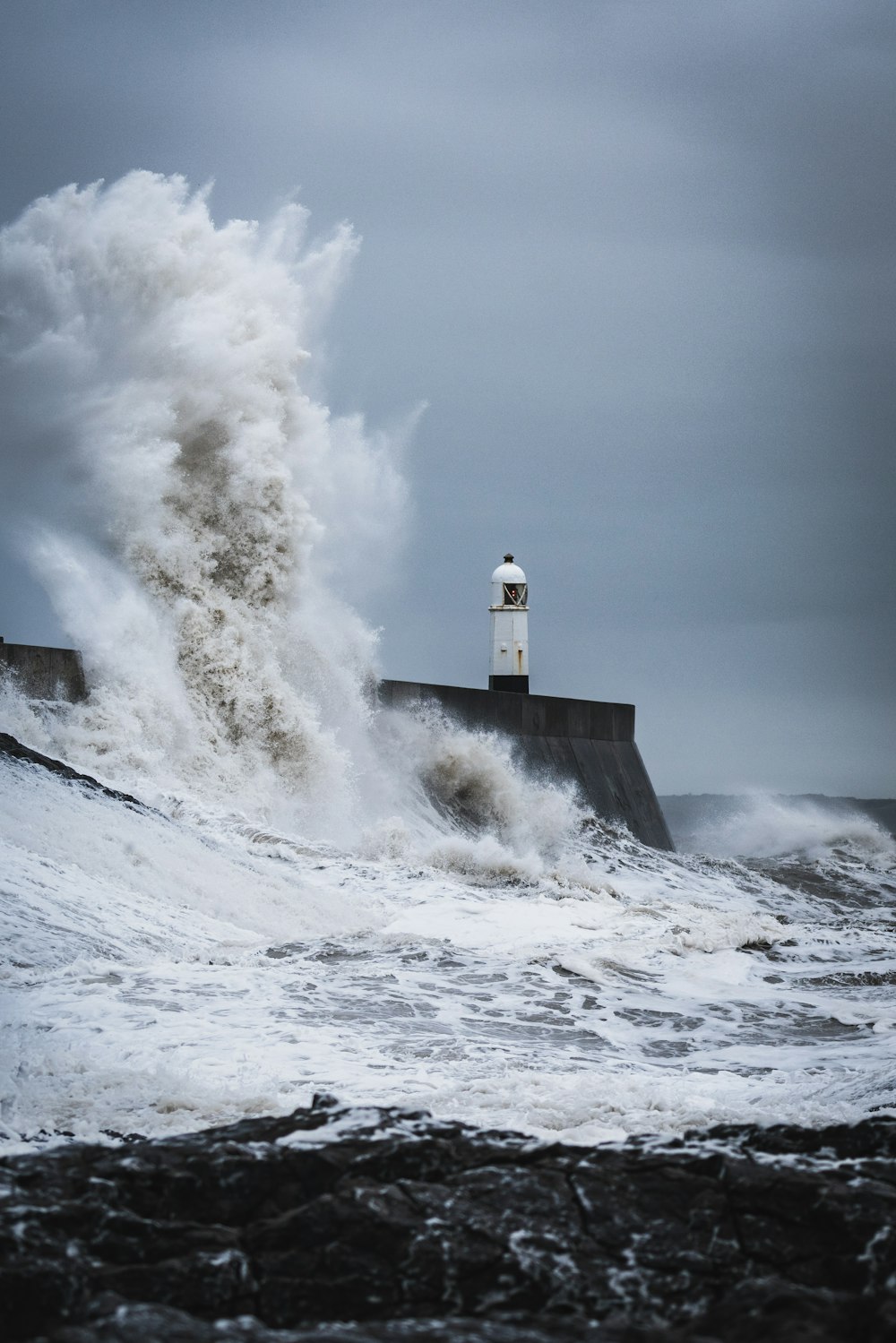 Ondas grandes batendo no farol durante o dia