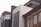 The image features a row of diverse architectural styles in an urban setting. A modern building with large tinted windows stands adjacent to an older brick structure with detailed brickwork and arched windows. The contrasting styles highlight the blend of contemporary and traditional design.