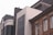 The image features a row of diverse architectural styles in an urban setting. A modern building with large tinted windows stands adjacent to an older brick structure with detailed brickwork and arched windows. The contrasting styles highlight the blend of contemporary and traditional design.