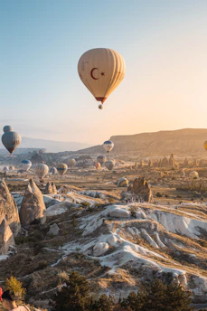 A breathtaking sunrise over the fairy chimneys of Cappadocia, with hot air balloons gently floating in the sky.