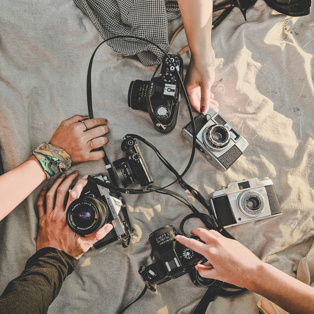 six assorted cameras on brown textile