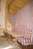 A cozy seating area bathed in warm red and yellow tones, inviting guests to relax.
