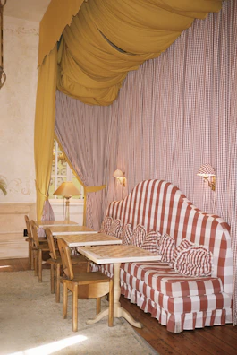 A cozy seating area bathed in warm red and yellow tones, inviting guests to relax.