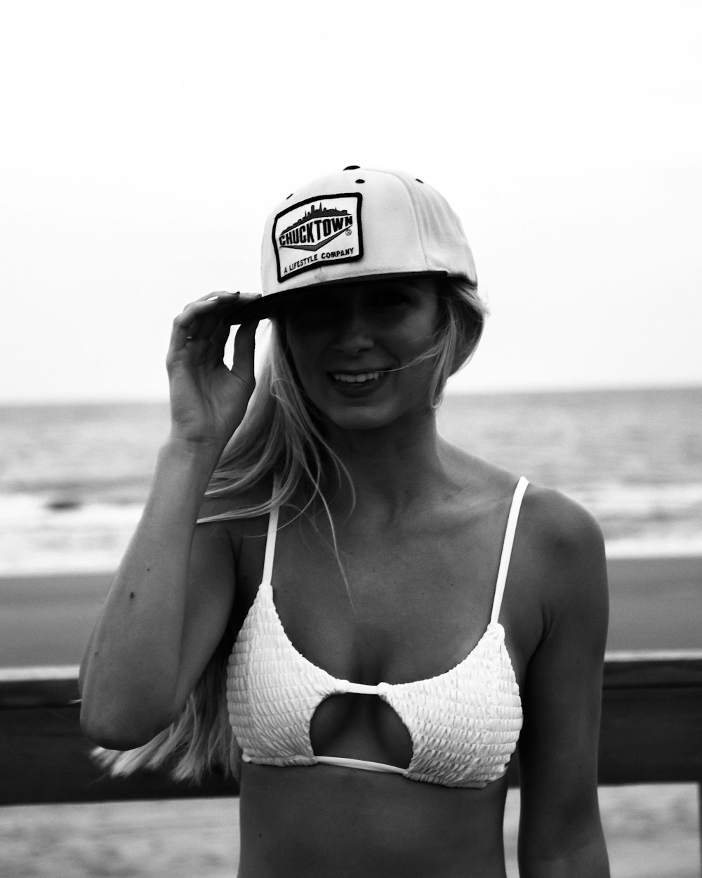 woman holding her cap grayscale photo