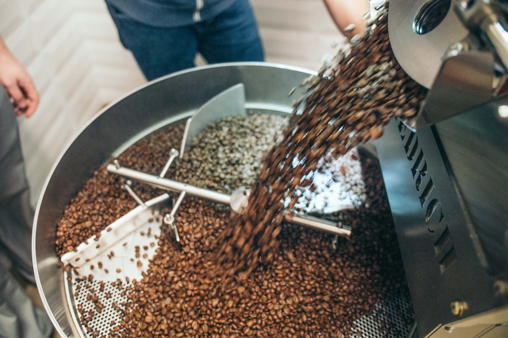 coffee machine pouring coffee in metal mixing container