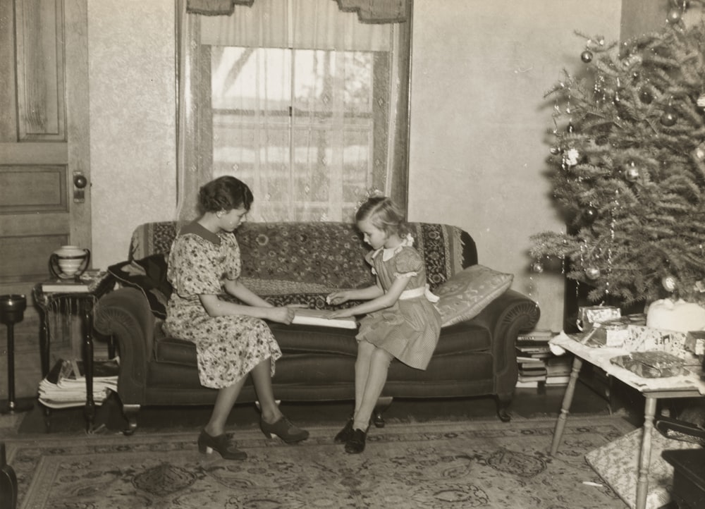 two women sitting on couch indoors