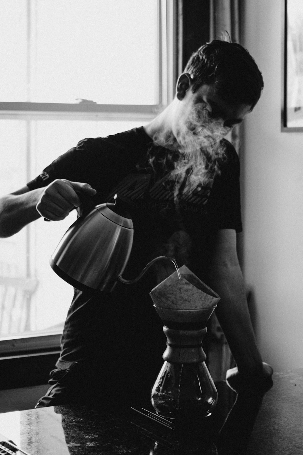 grayscale photography of man holding kettle