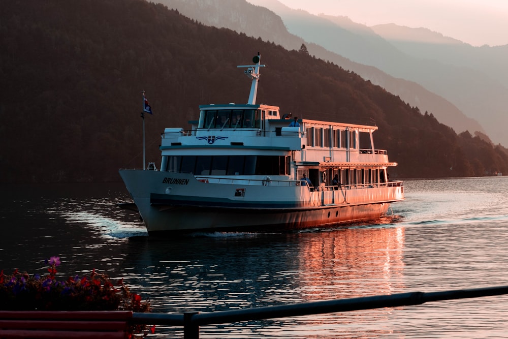 ship floating on body of water near mountain