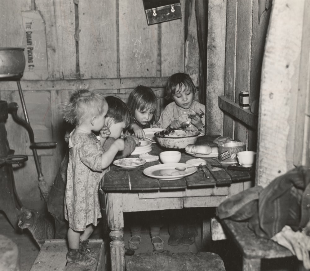 grayscale photography toddlers eating indoors