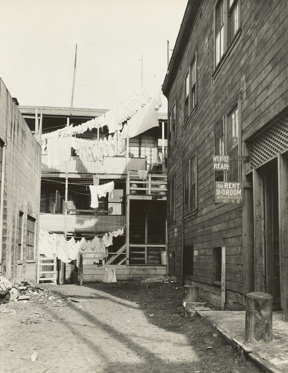 a black and white photo of clothes hanging outside a building