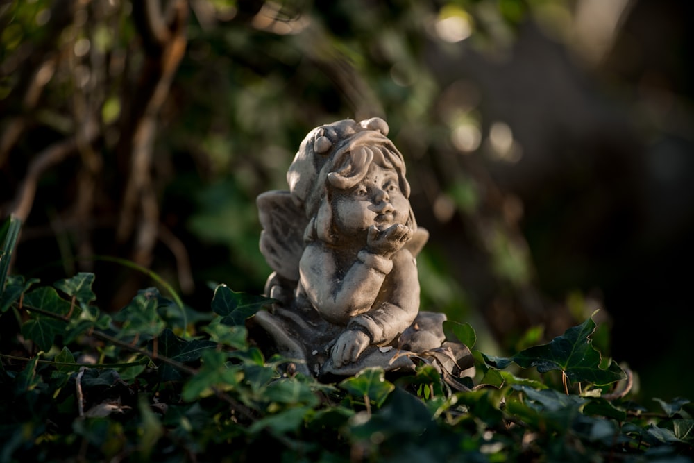 Menina inclinando-se para a frente estatueta em folhas verdes