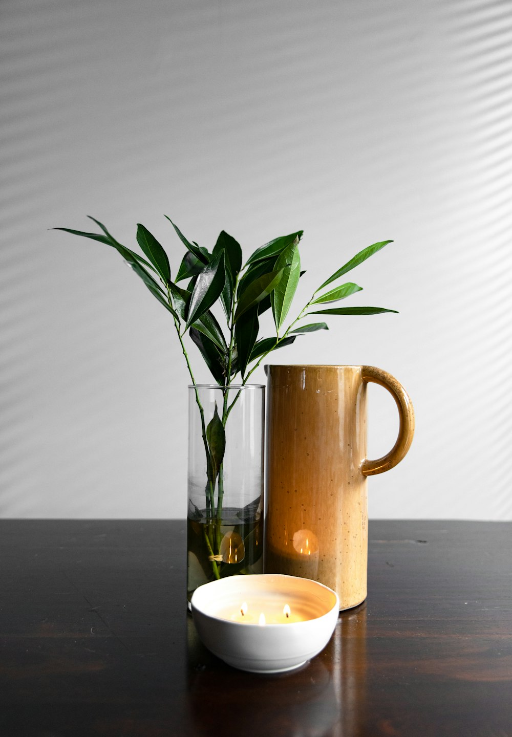 brown pitcher beside plant in vase