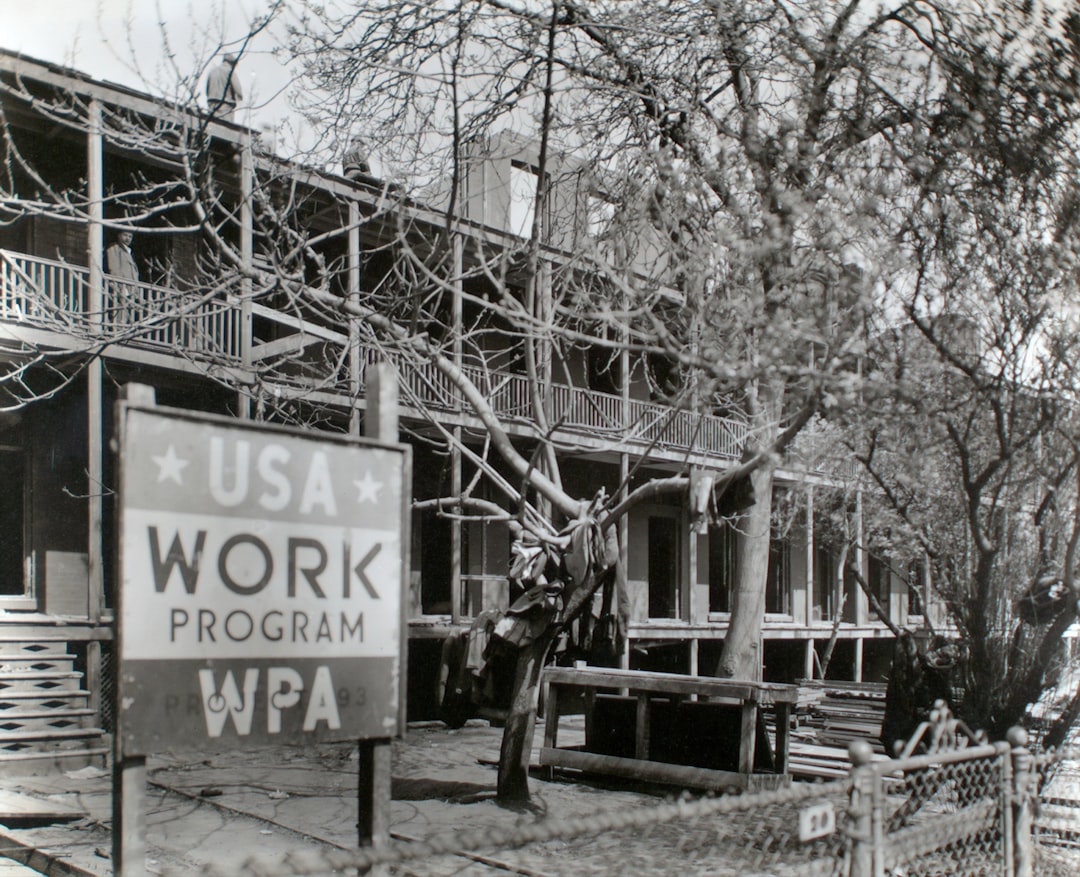 grayscale photography of bare trees near building