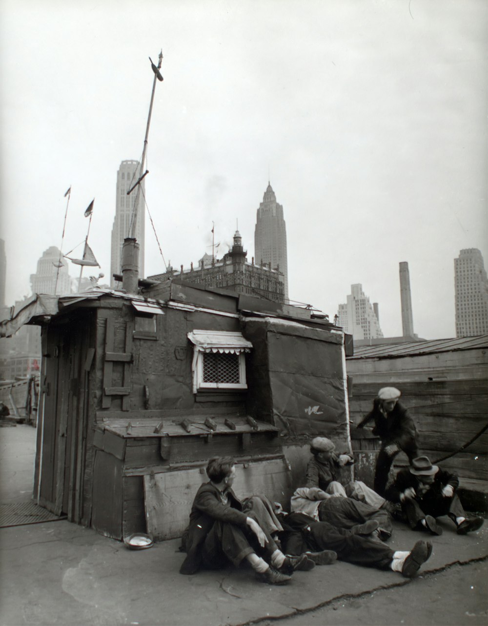 grayscale photography of five people sitting near house