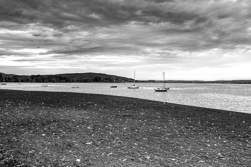 grayscale photography of boats on body of water viewing mountain