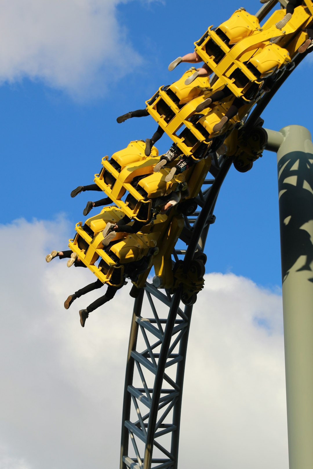 people riding in amusement ride under blue and white skies during daytime